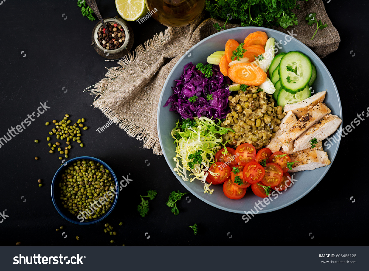 Healthy salad with chicken, tomatoes,  cucumber, lettuce, carrot, celery, red cabbage and  mung bean on dark background. Proper nutrition. Dietary menu. Flat lay. Top view #606486128