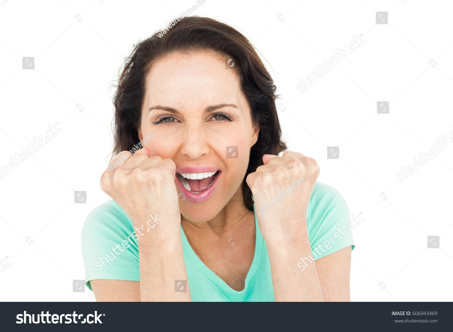 Pretty woman celebrating victory against white background #606943469