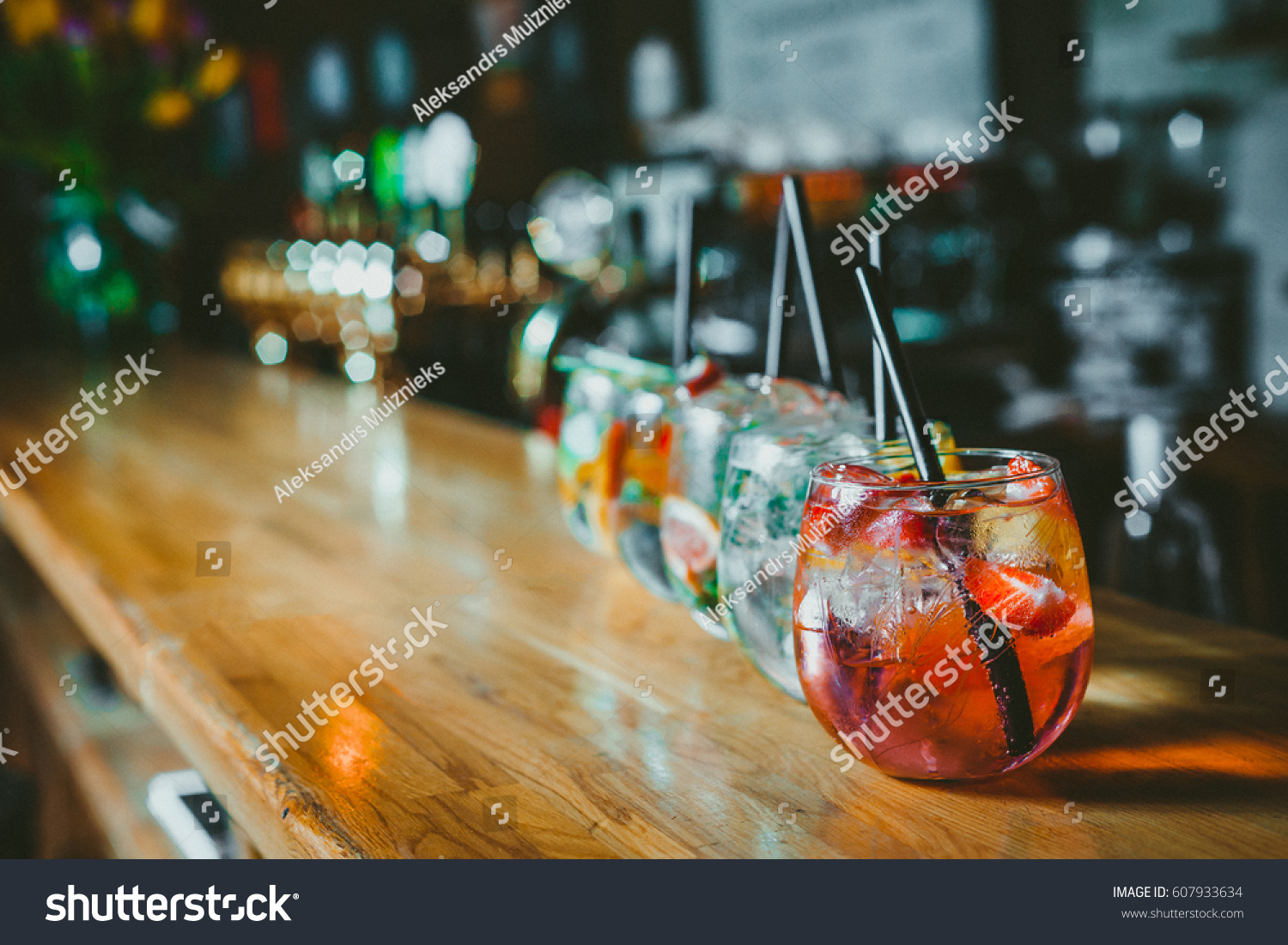Alcoholic cocktail row on bar table, colorful party drinks  #607933634