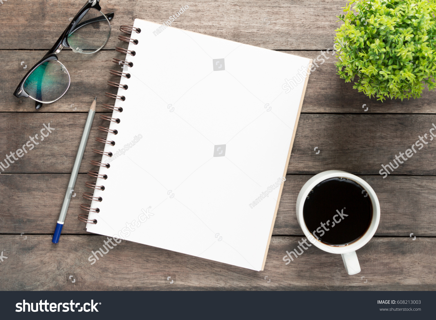 Office atable with blank notebook and laptop  /  Coffee cup #608213003