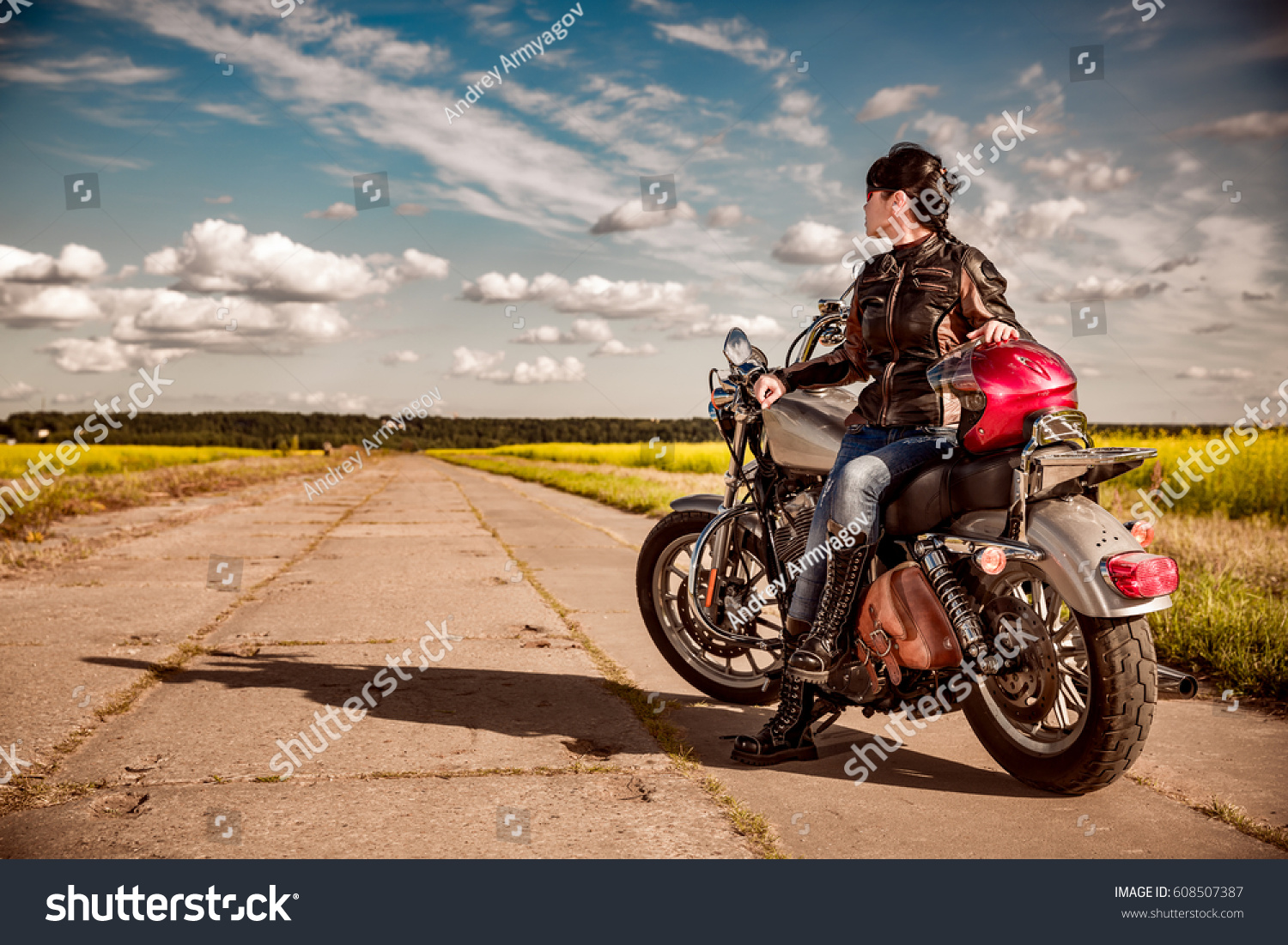 Biker girl in a leather jacket on a motorcycle #608507387