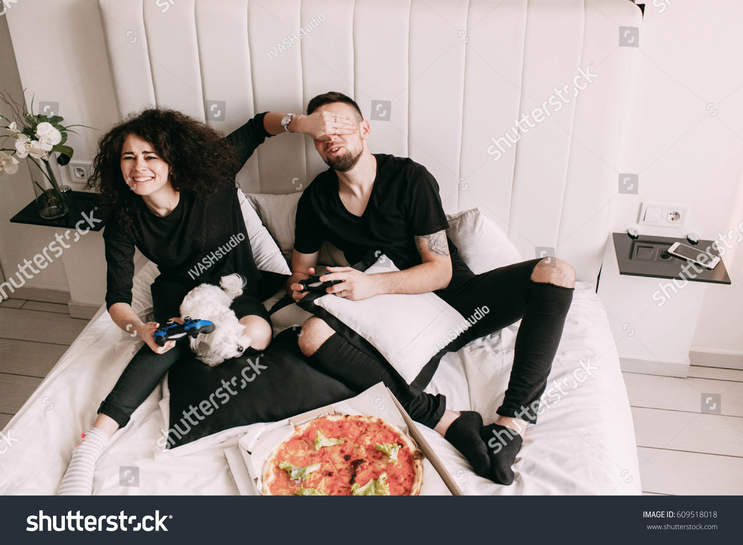 Girl closes man's eyes while they play PS #609518018