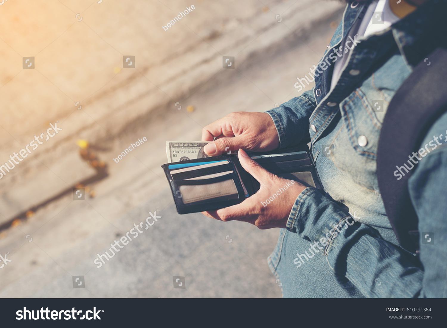 Hipster man hands holding wallet with credit cards and stack of money. #610291364