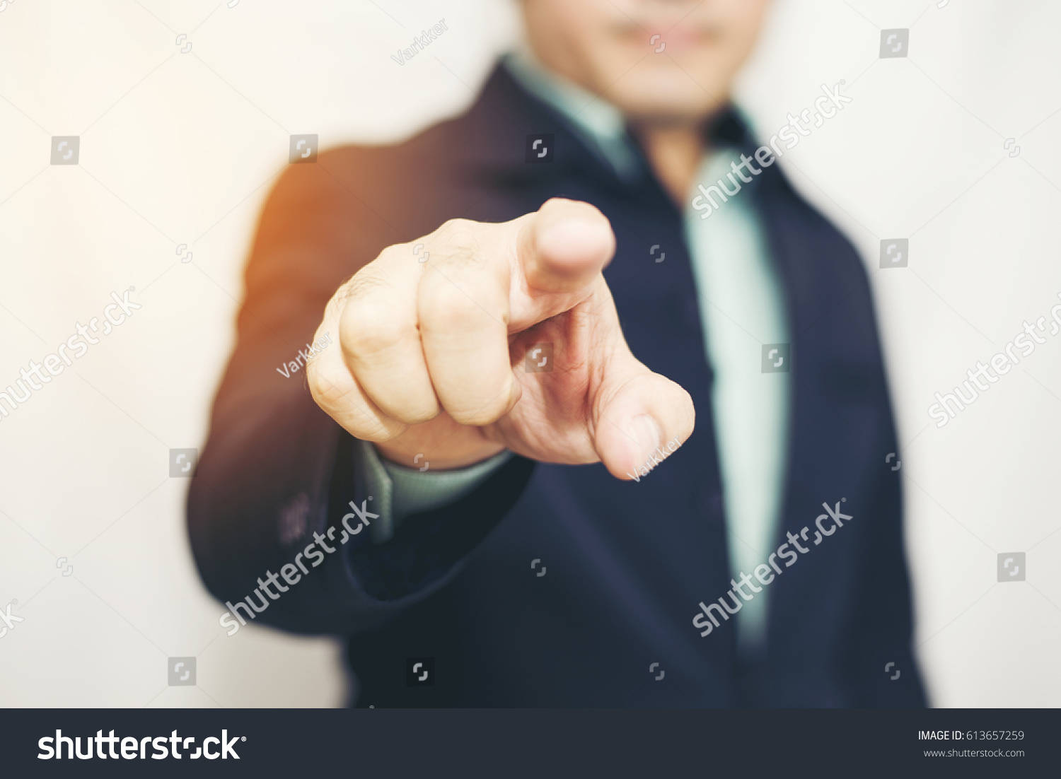 Business man pointing finger soft focus background #613657259