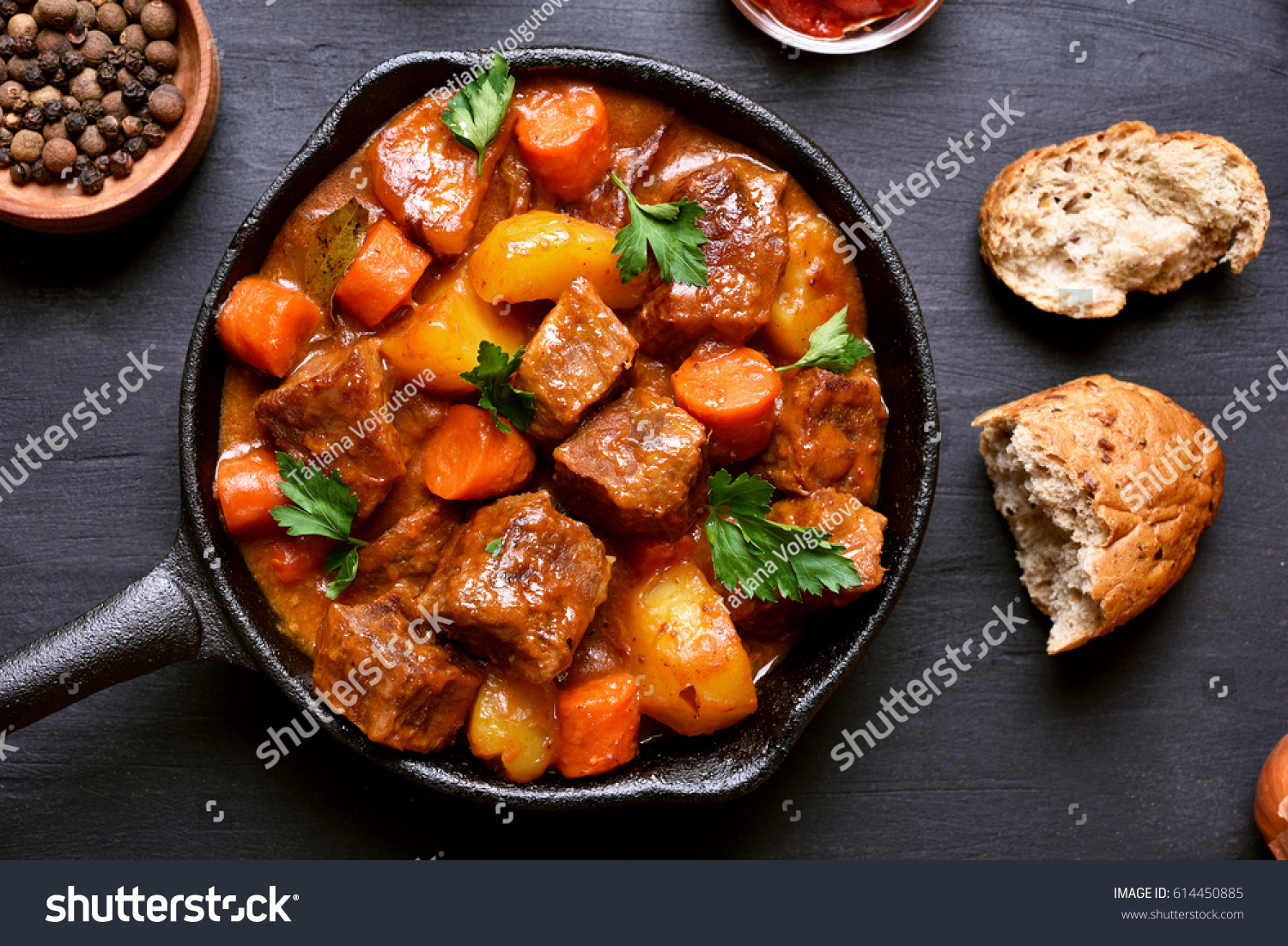 Goulash, beef stew in cast iron pan on dark background, top view, close up #614450885