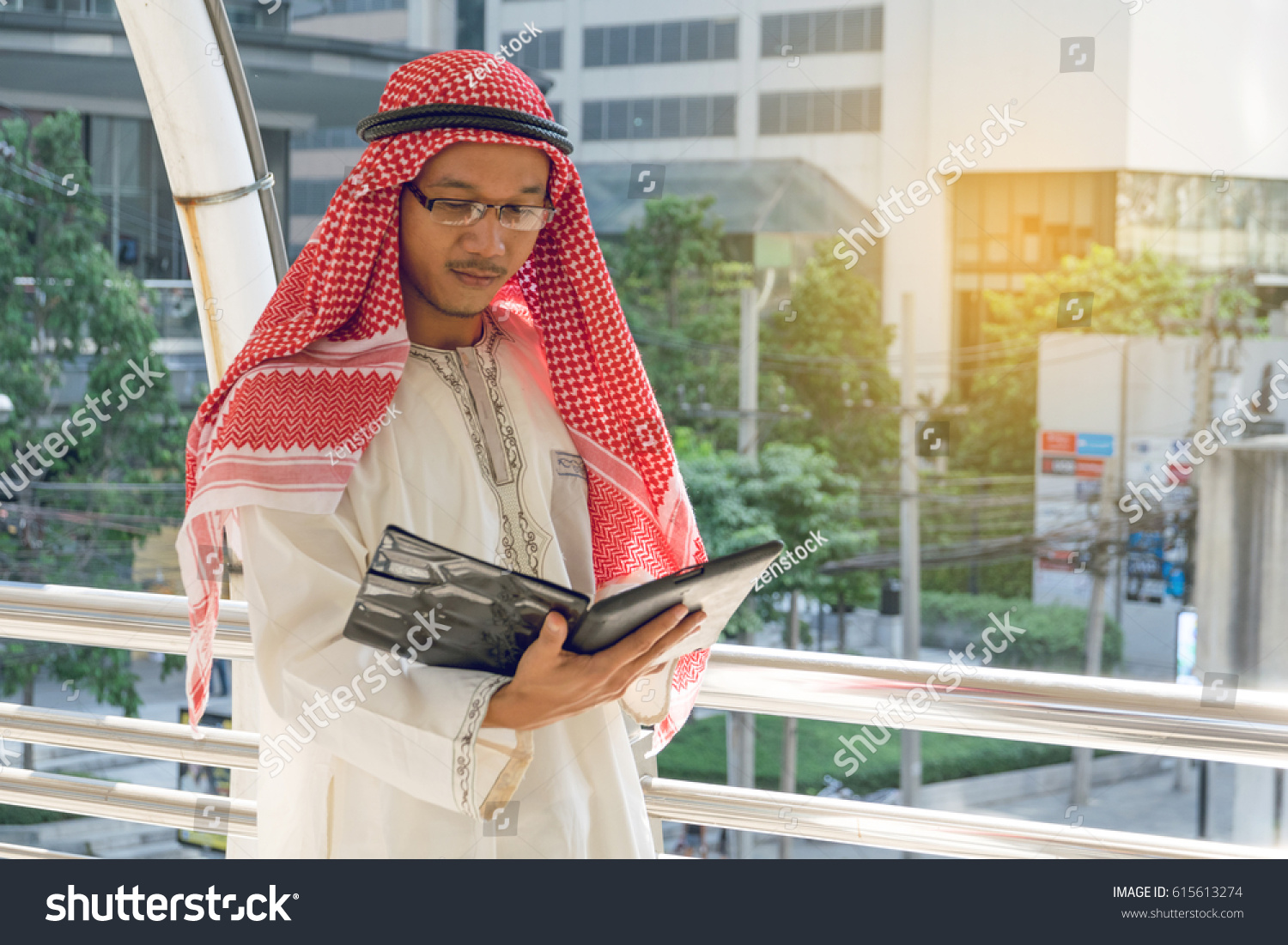 Arab businessman messaging on a mobile phone in the city #615613274