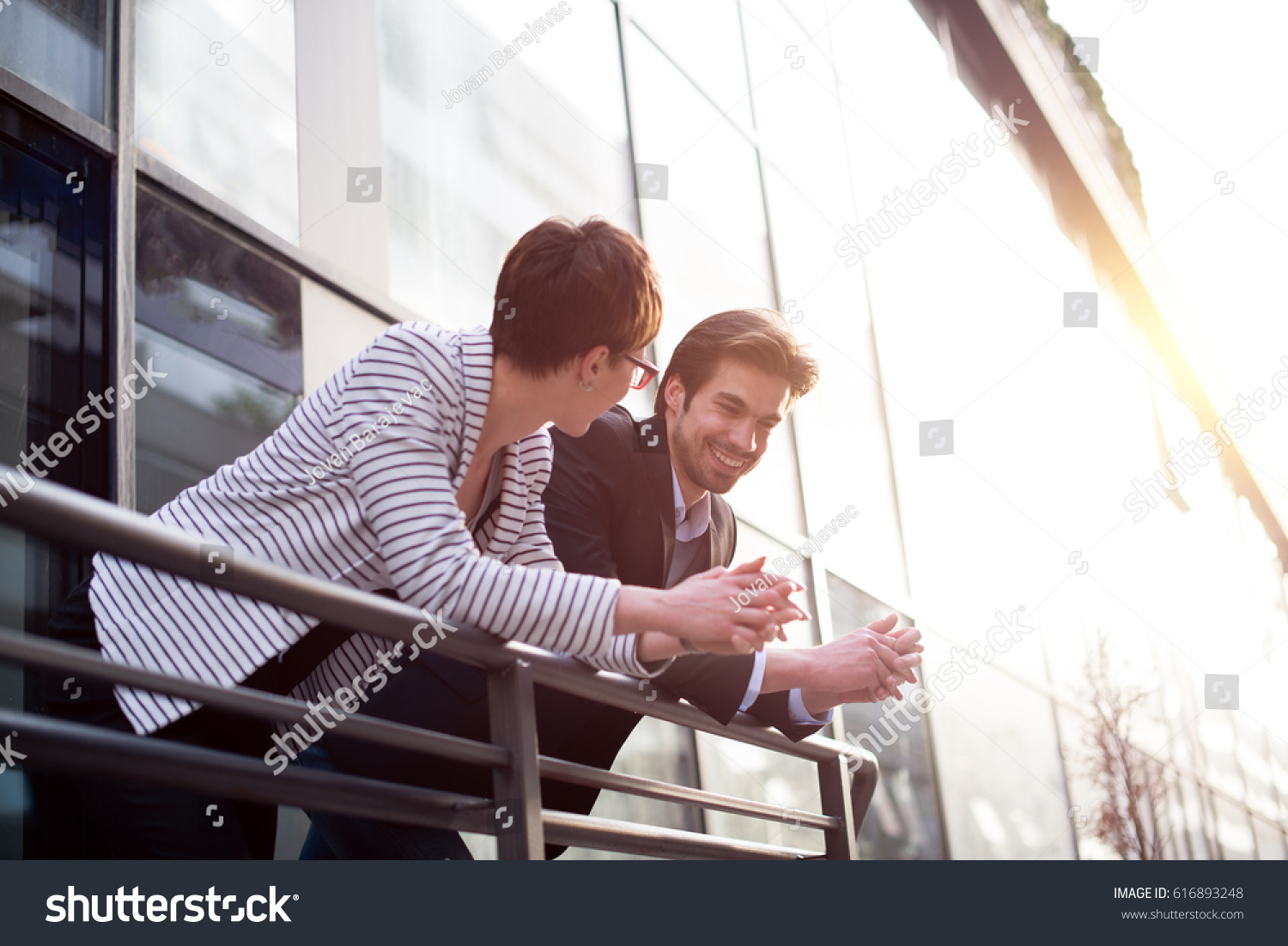 Businessman explains something to businesswoman on balcony #616893248