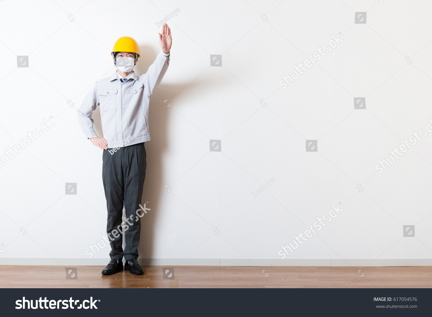 Men standing wearing work clothes with a white background #617054576