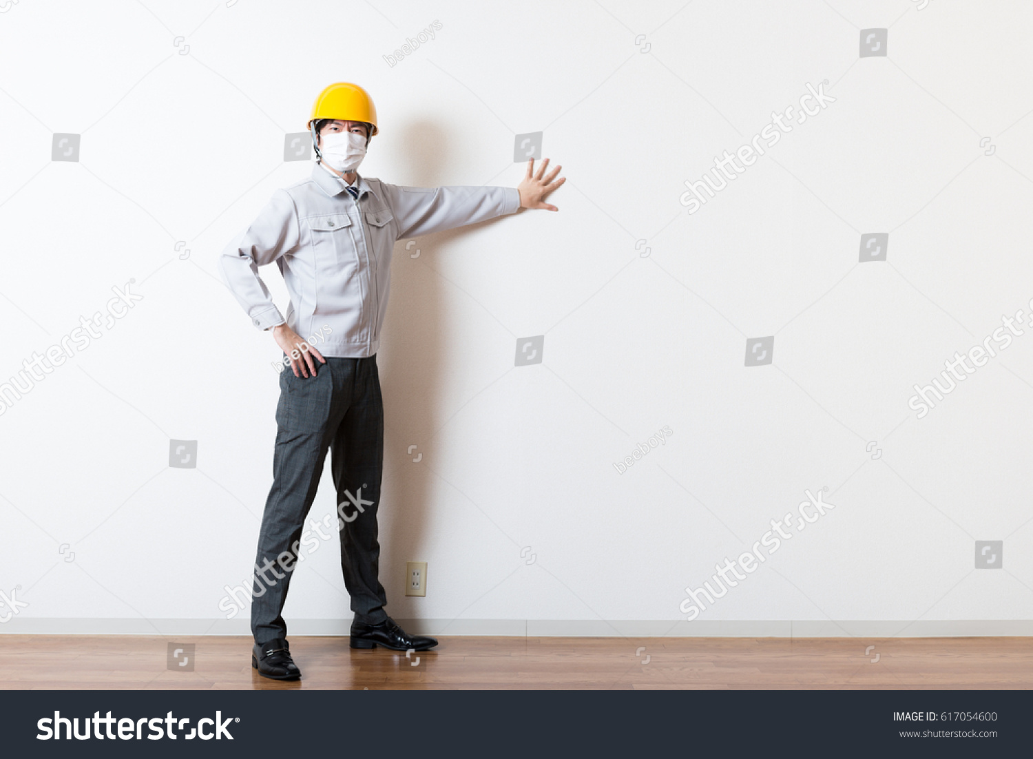 Men standing wearing work clothes with a white background #617054600