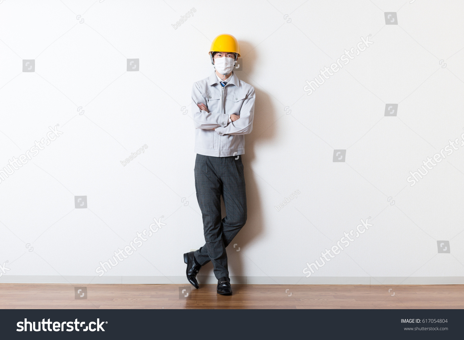 Men standing wearing work clothes with a white background #617054804