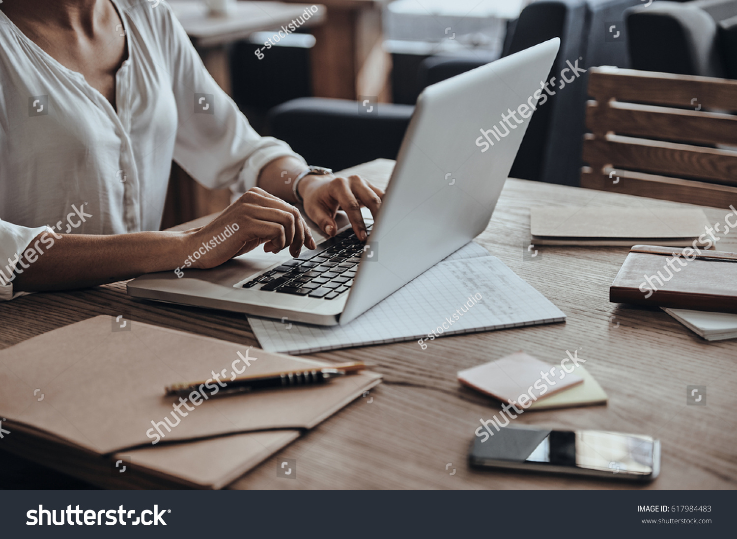 Full concentration at work. Close-up of African woman using computer while sitting in cafe #617984483