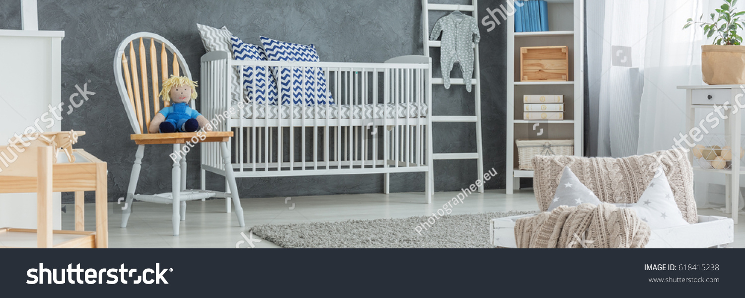White cradle with patterned pillows in cozy baby boy bedroom #618415238