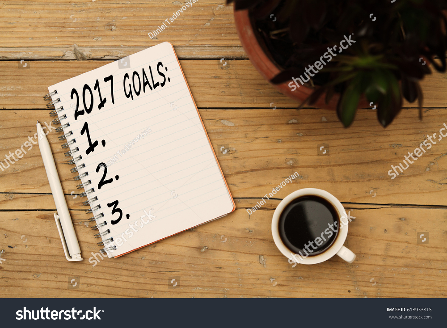 Top view 2017 goals list with notebook, flower, cup of coffee on wooden desk #618933818