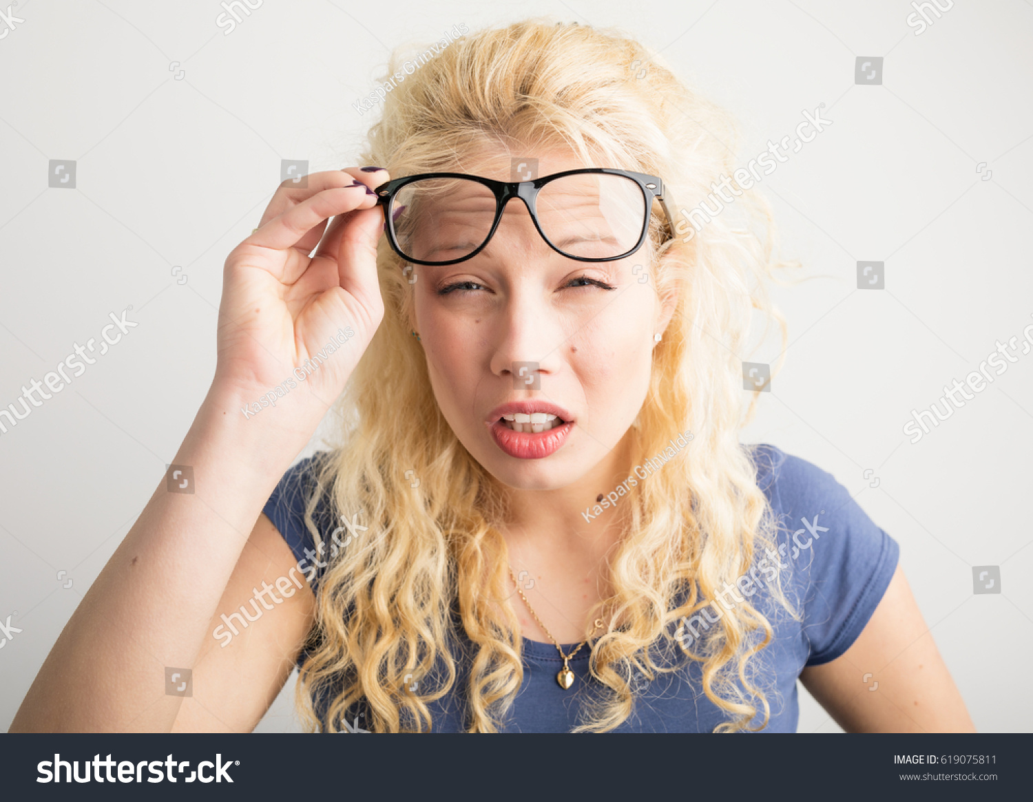 Woman with her glasses lifted up can't see #619075811