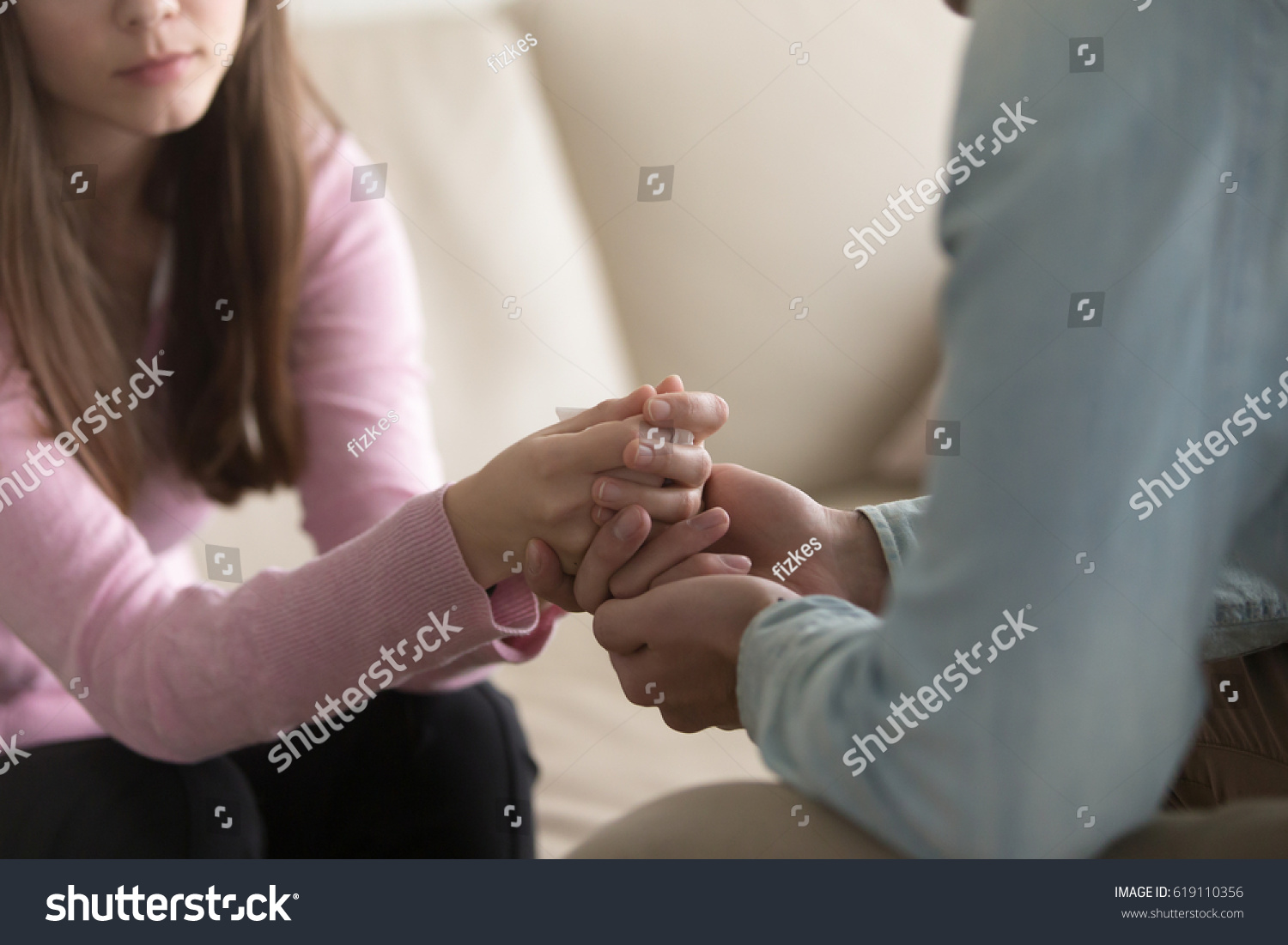 Close up view of upset couple, guy holding hands of crying woman, trying to comfort and console her, boyfriend apologizing offended lady, asking for forgiveness. Support, regret and compassion  #619110356