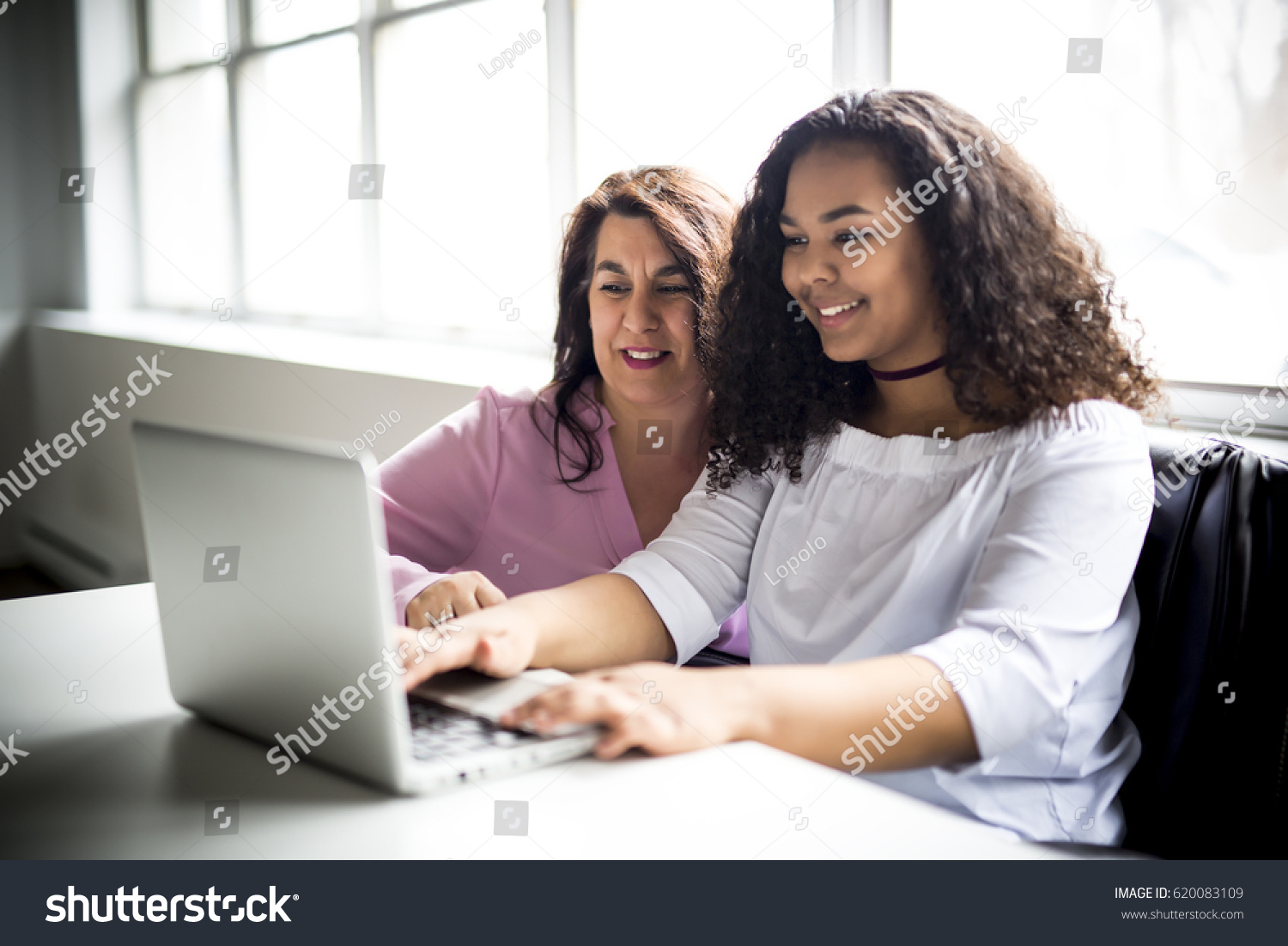 A Mother And Teenage Daughter Looking At Laptop Together #620083109