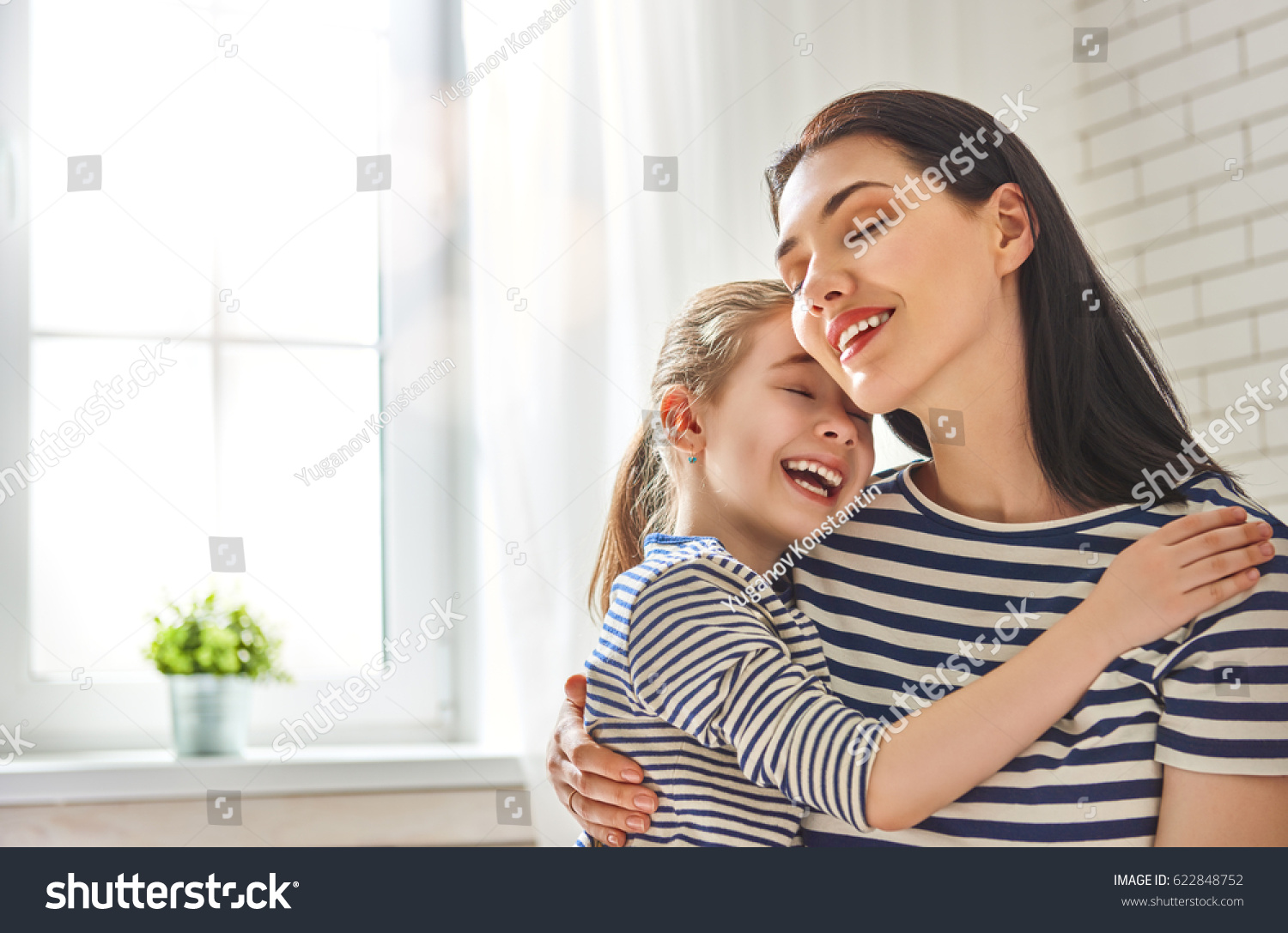 Happy mother's day! Mom and her daughter child girl are playing, smiling and hugging. Family holiday and togetherness. #622848752