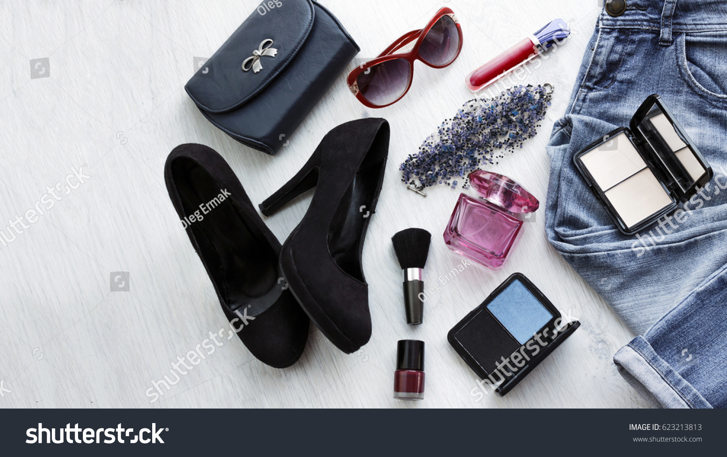 Close up trendy accessories for young woman. Overhead clutch, jeans and black shoes #623213813