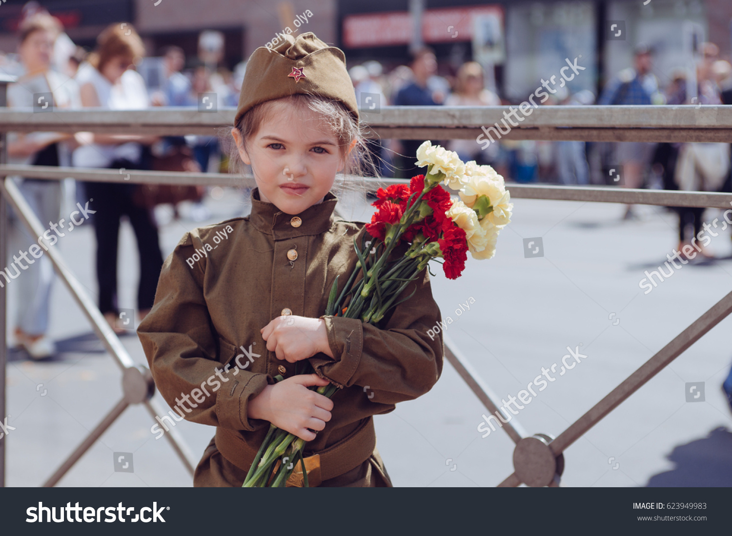 Little girl with flowers on the holiday of May 9, the day of victory in Russia #623949983