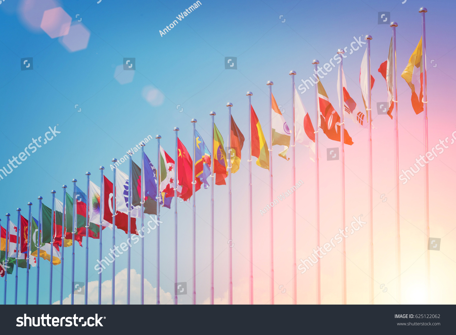 Flags of different countries on the background of the blue sky in the sunlight #625122062