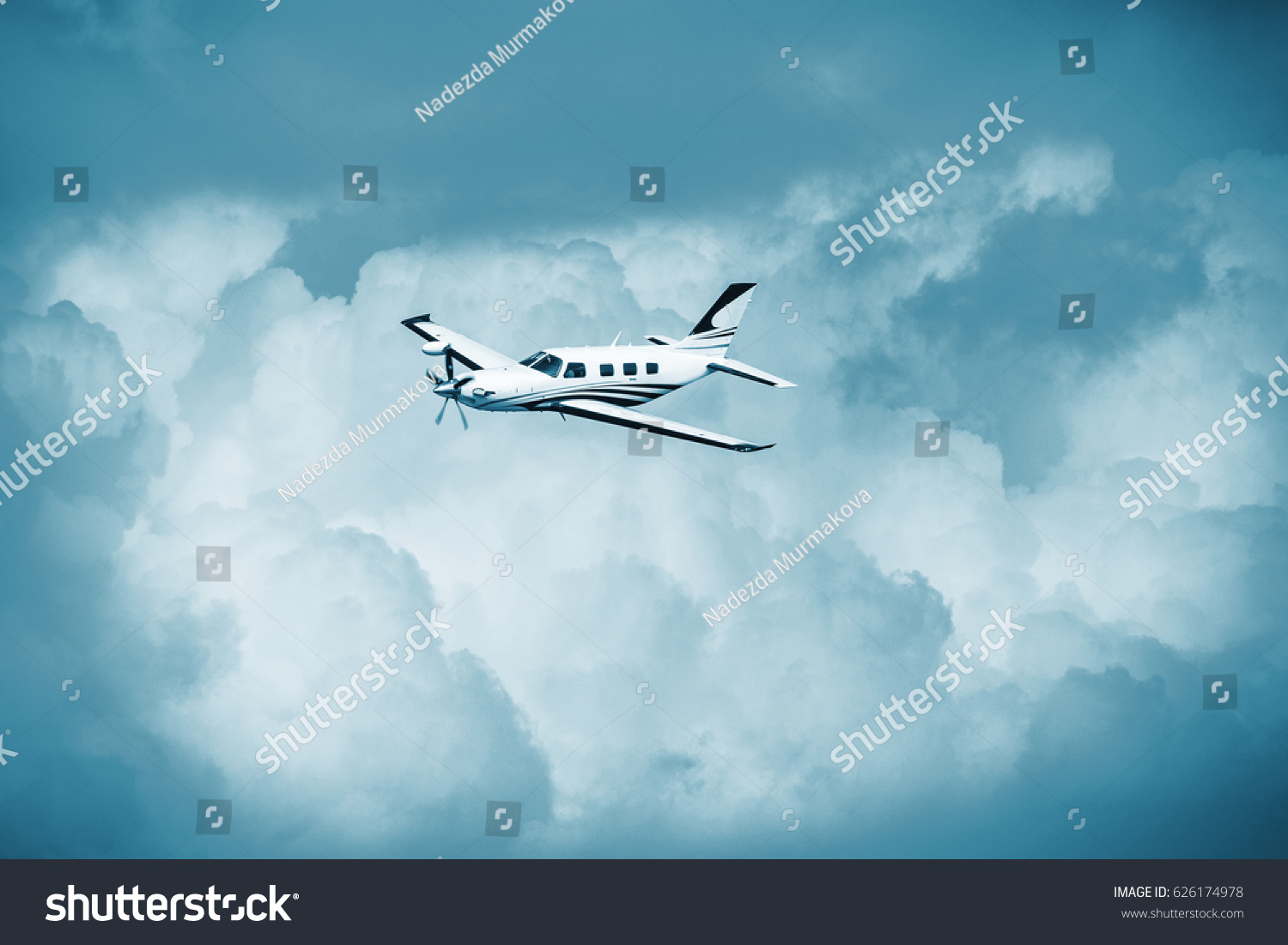 Single piston aircraft. Single-propeller aircraft flying over the blue sky. Single turboprop aircraft.. Small private plane flying in blue clouds. #626174978