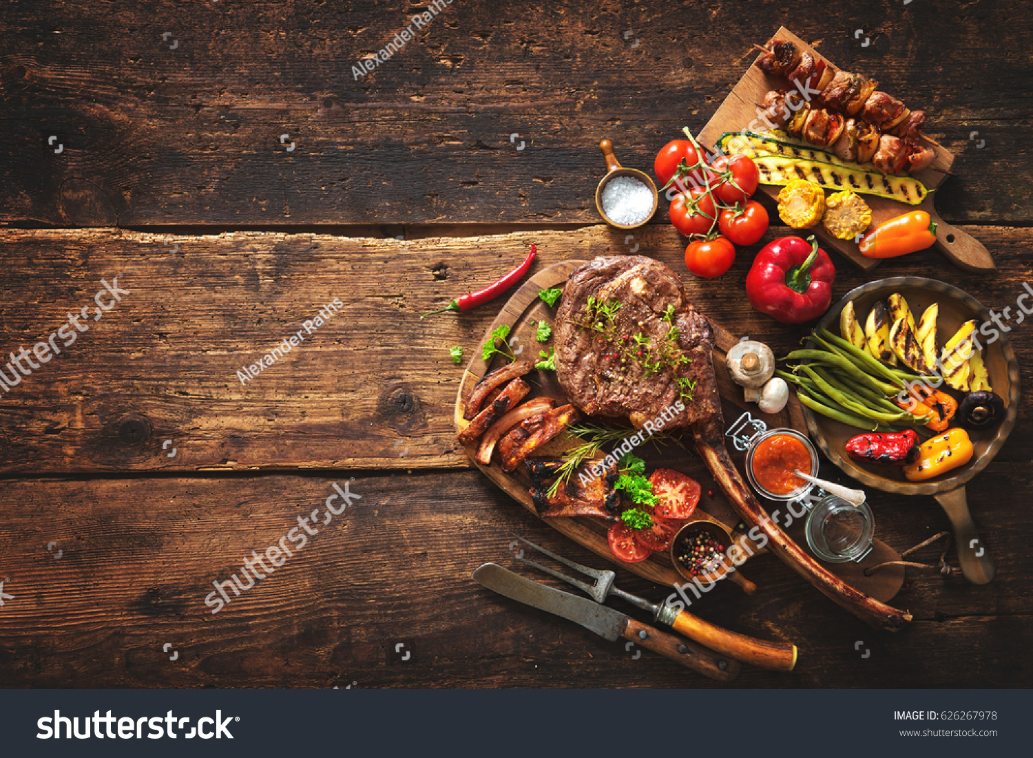 Grilled meat and vegetables on rustic wooden table #626267978