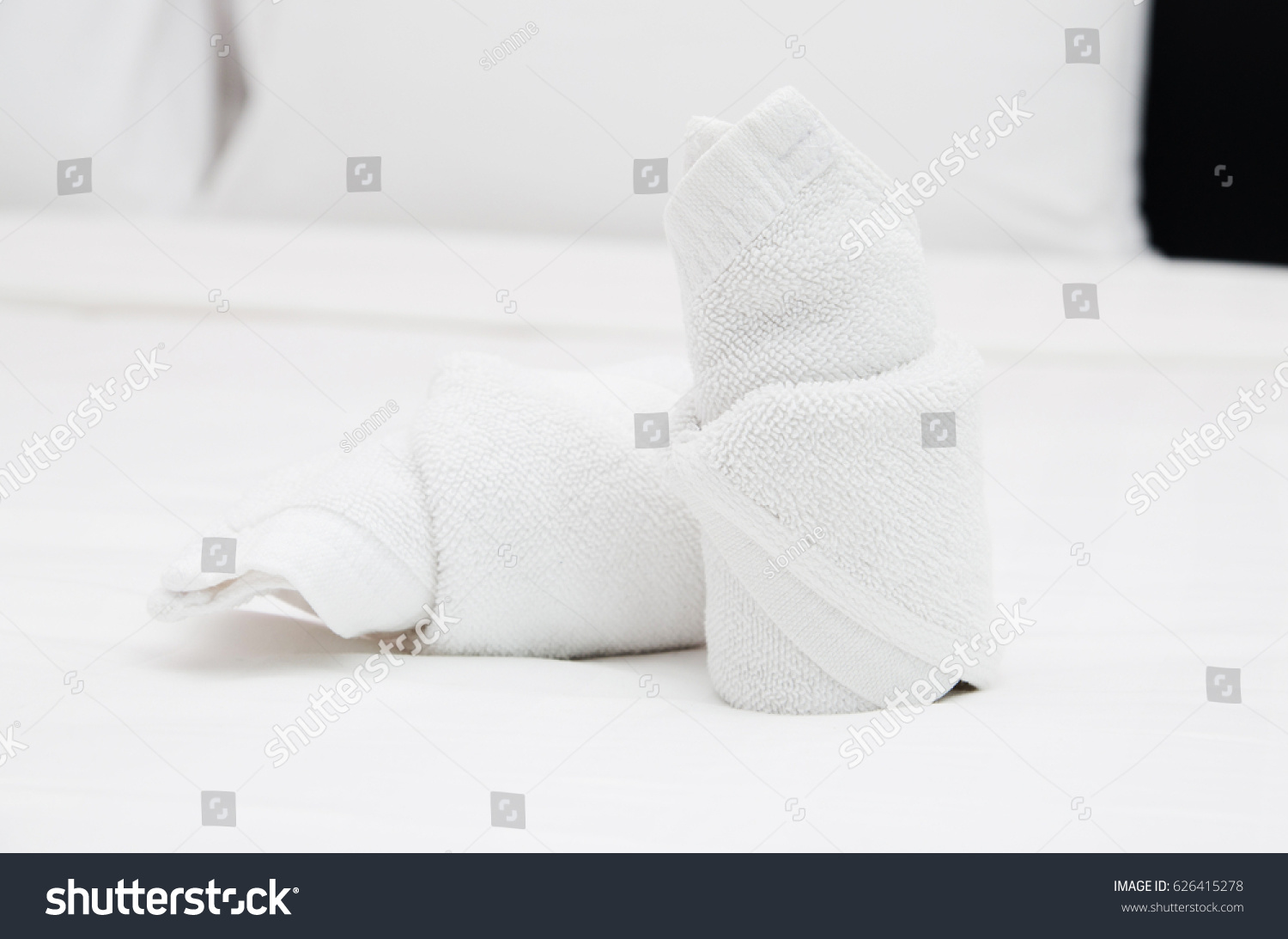 Bath towels on the bed of hotel bedroom #626415278
