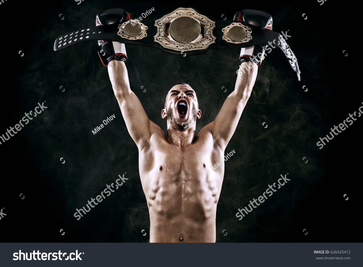 Boxer with Champion belt celebrating flawless victory isolated on black background with copy Space.. #626425412