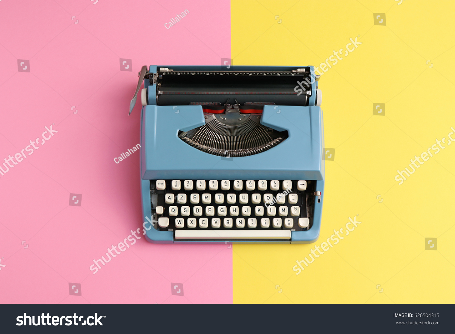 Vintage blue typewriter over a pastel background. #626504315