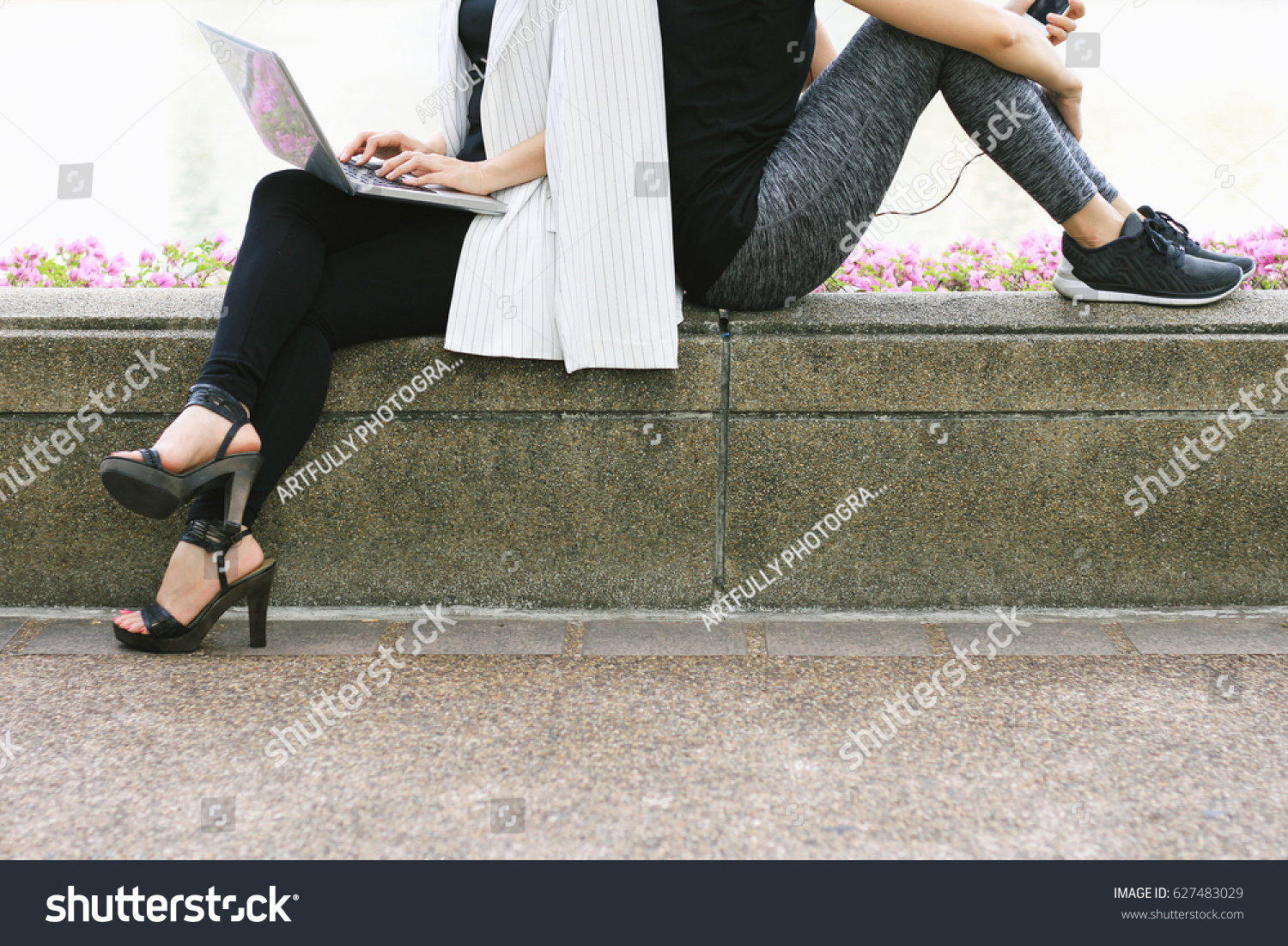 Business woman working on the laptop computer sitting near the relaxing sport woman in city park, Life balance concept, Workaholic and healthy lifestyle. #627483029