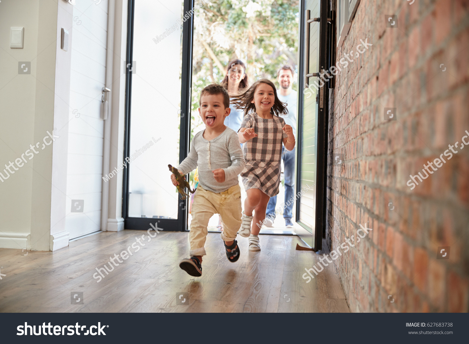 Excited Children Arriving Home With Parents #627683738