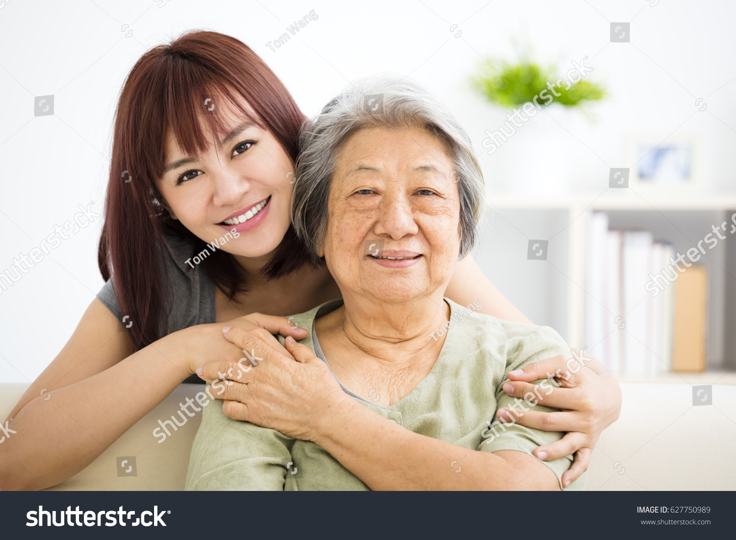 Grandmother and granddaughter. Young woman carefully takes care of old woman #627750989