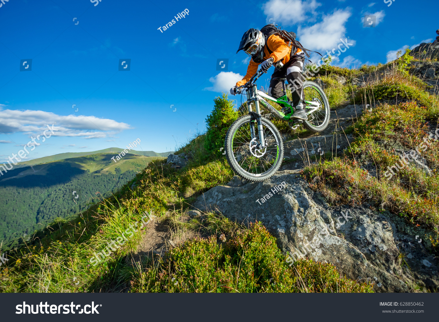 A man is riding bicycle, on the background of mountains and blue sky. Beautiful summer day. Mountain bike race #628850462