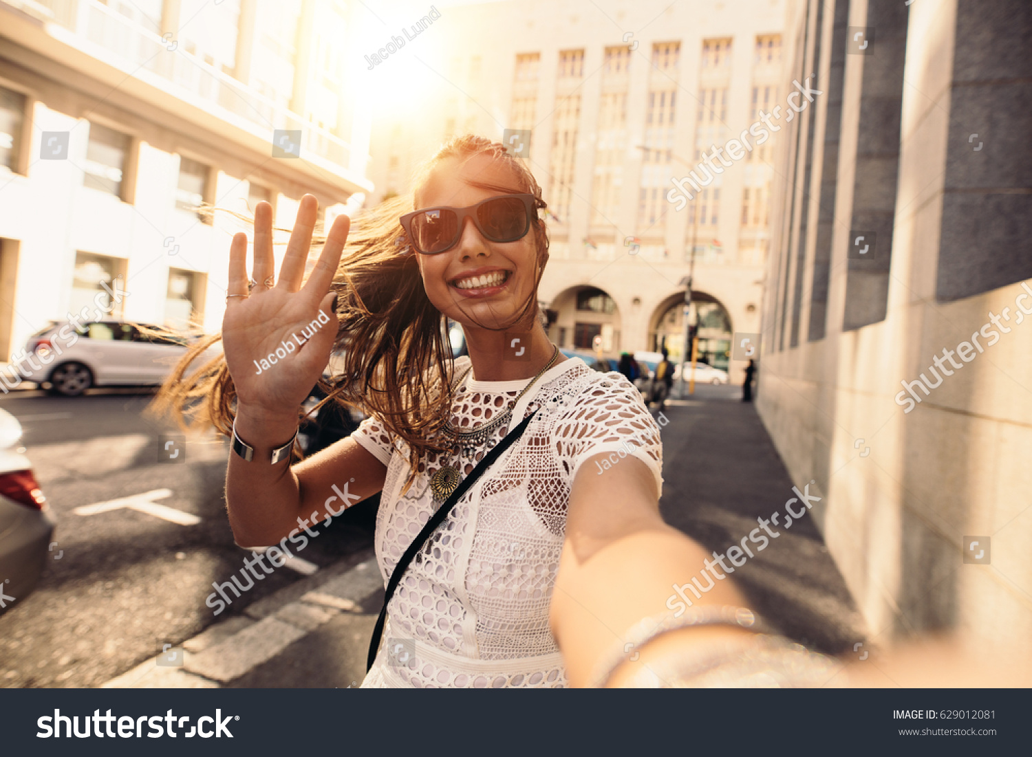 Tourist posing for a selfie in a street. Vlogger recording content for her travel vlog. #629012081