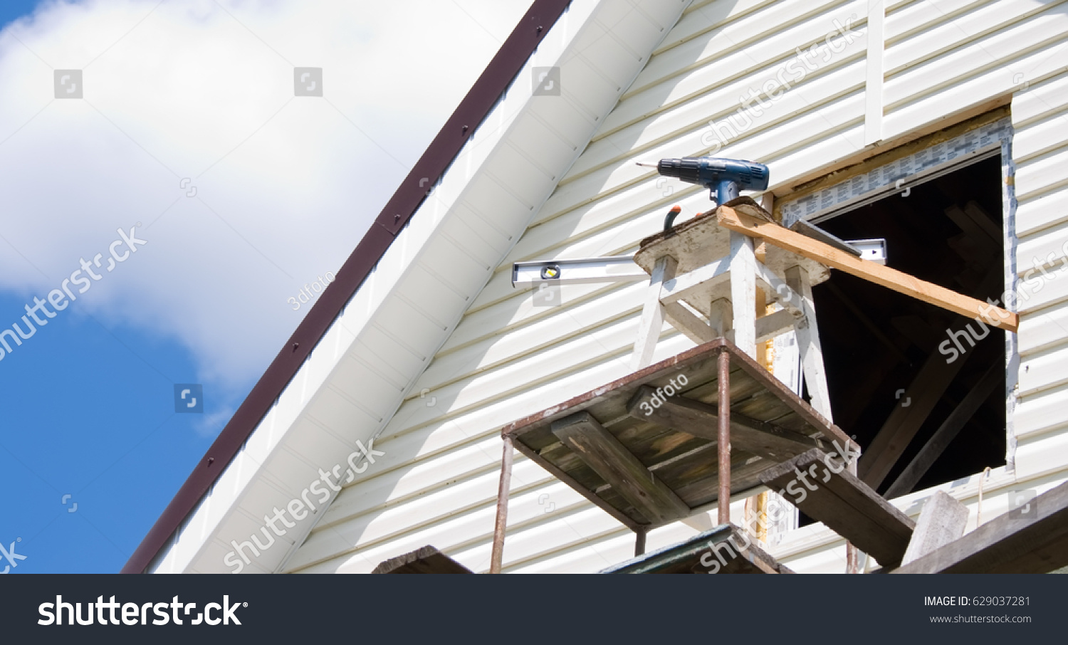 Installation of a siding on a house against the sky #629037281