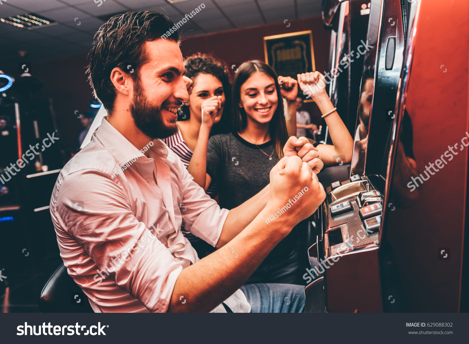Group of friends playing slot machines #629088302
