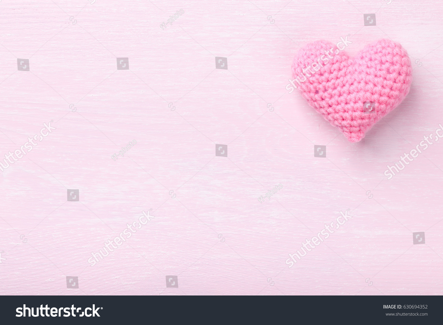 Crochet pink heart on pink wooden background #630694352