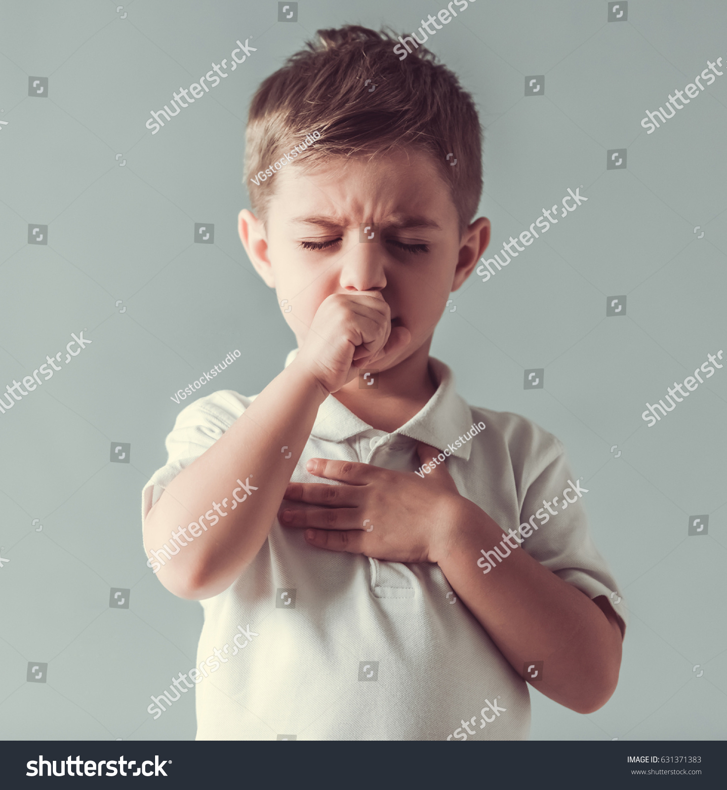 Cute little boy is coughing, on gray background #631371383