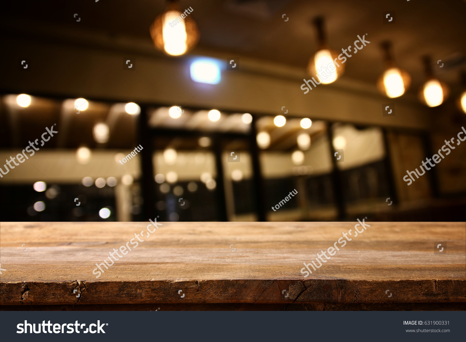Image of wooden table in front of abstract blurred restaurant lights background. #631900331
