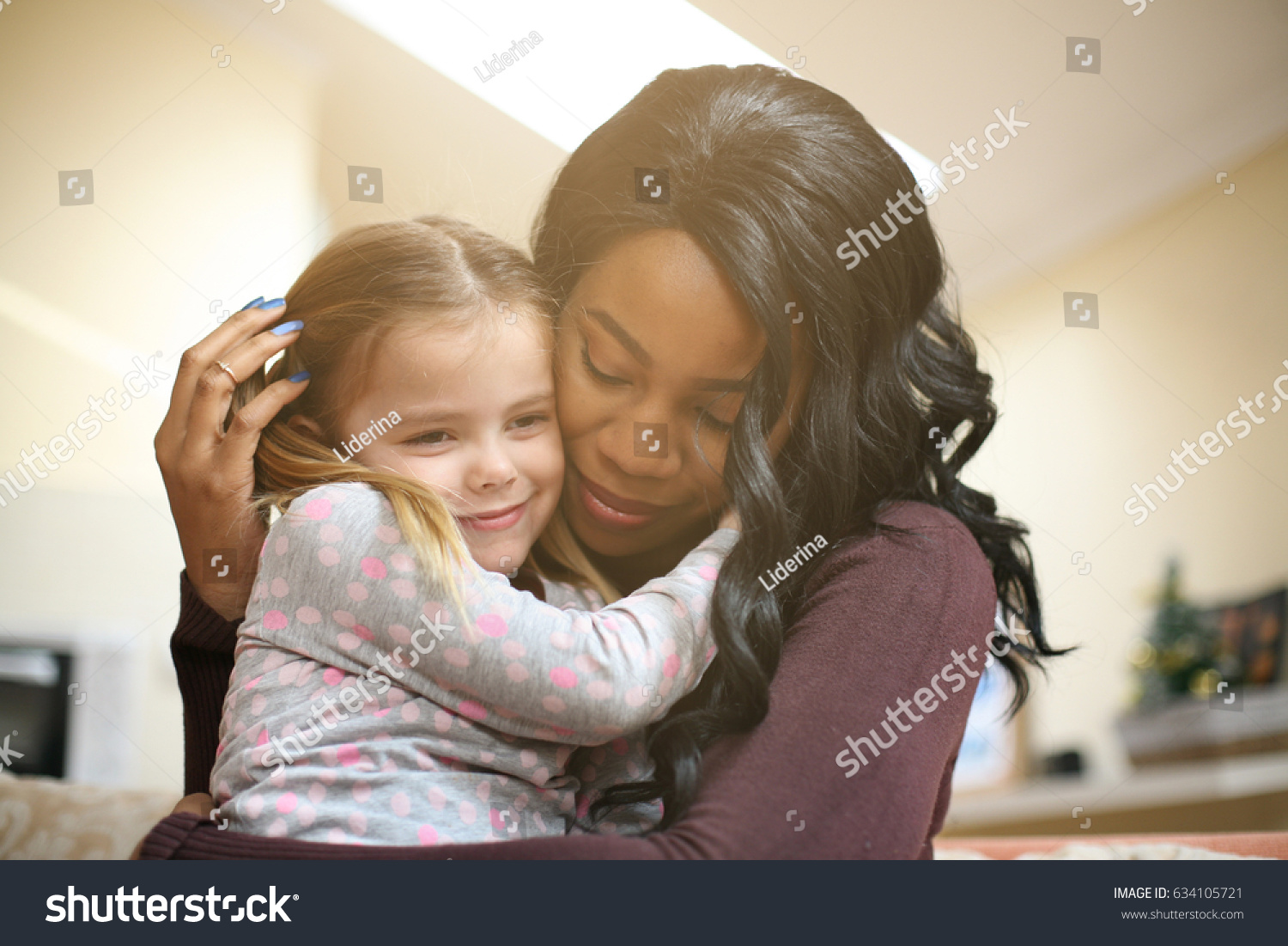 African American woman playing with girl. Woman hugging her adopted daughter.
 #634105721