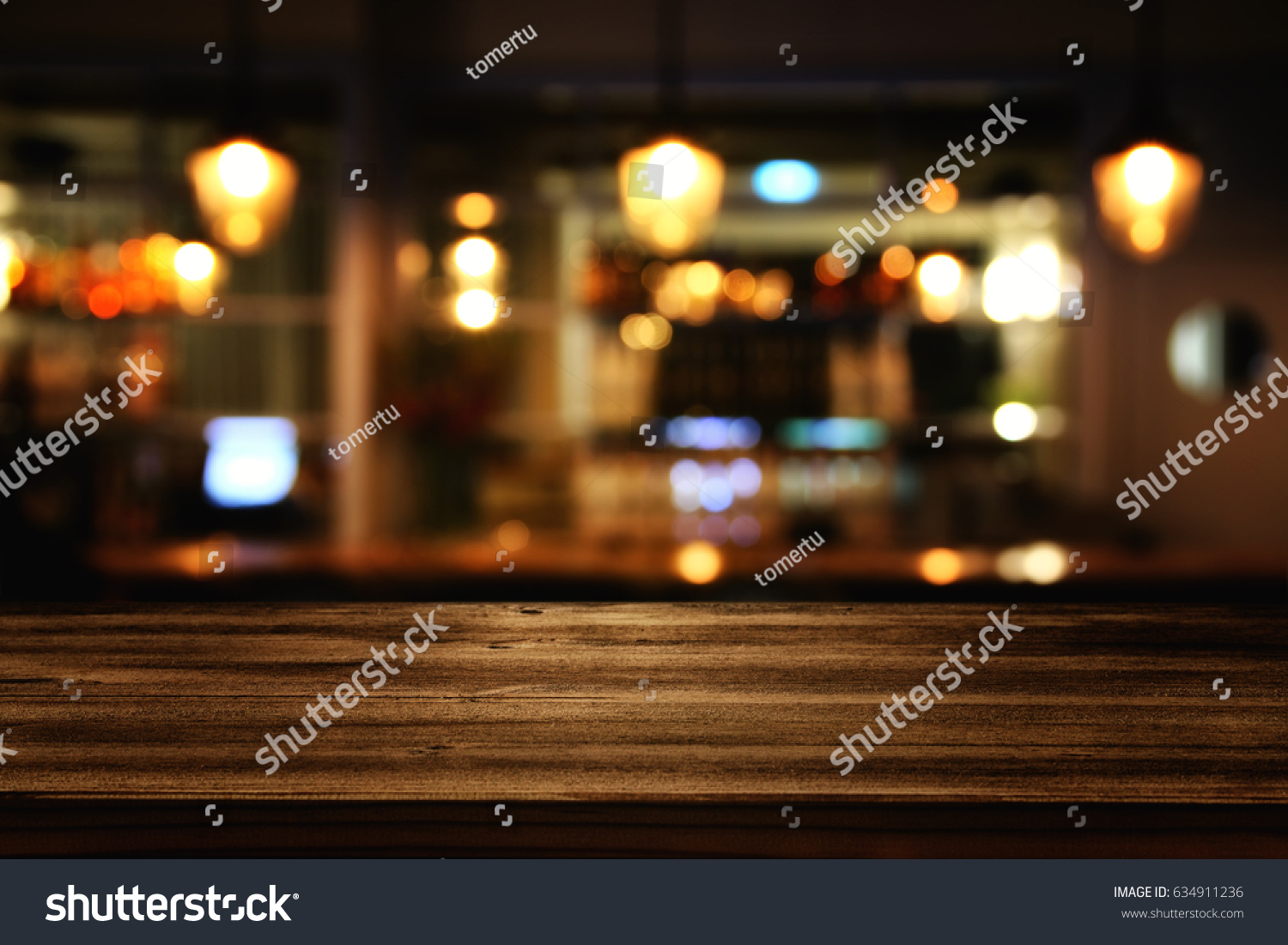 Image of wooden table in front of abstract blurred restaurant lights background. #634911236