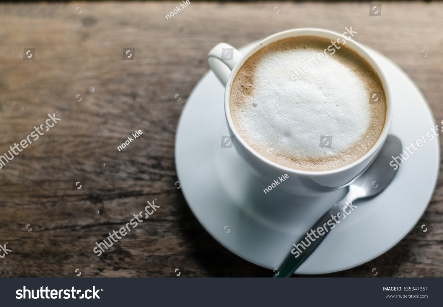 A cup of coffee in a white cup on wooden background #635347367