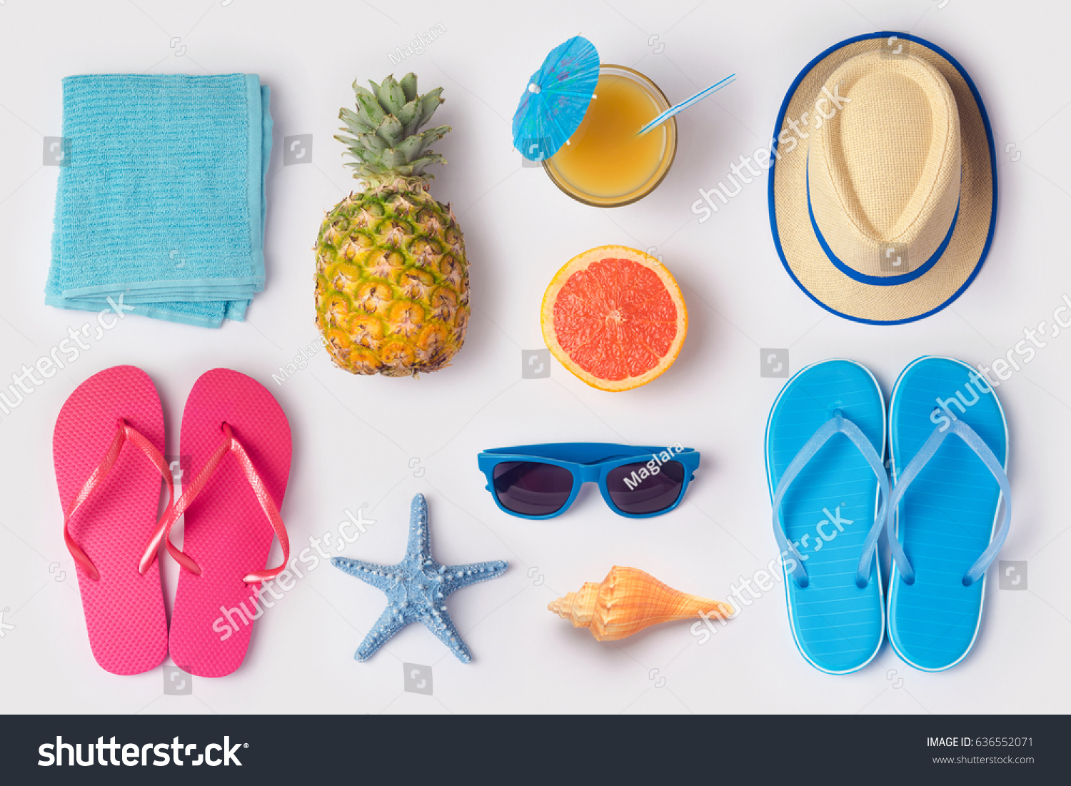 Tropical summer vacation concept with pineapple, juice and flip flops organized on white background. View from above. Flat lay