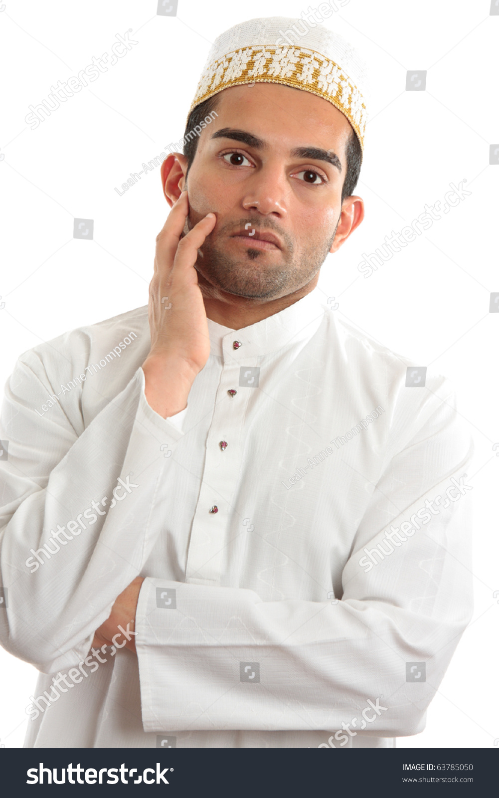 A man wearing cultural ethnic robe and decorative topi thinking.  White background. #63785050