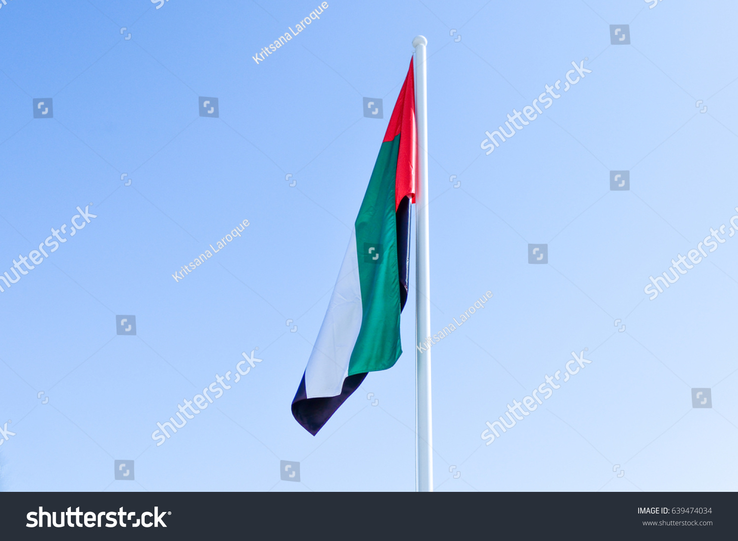 A United Arab Emirates flag flying against clean and tranquil sky. #639474034