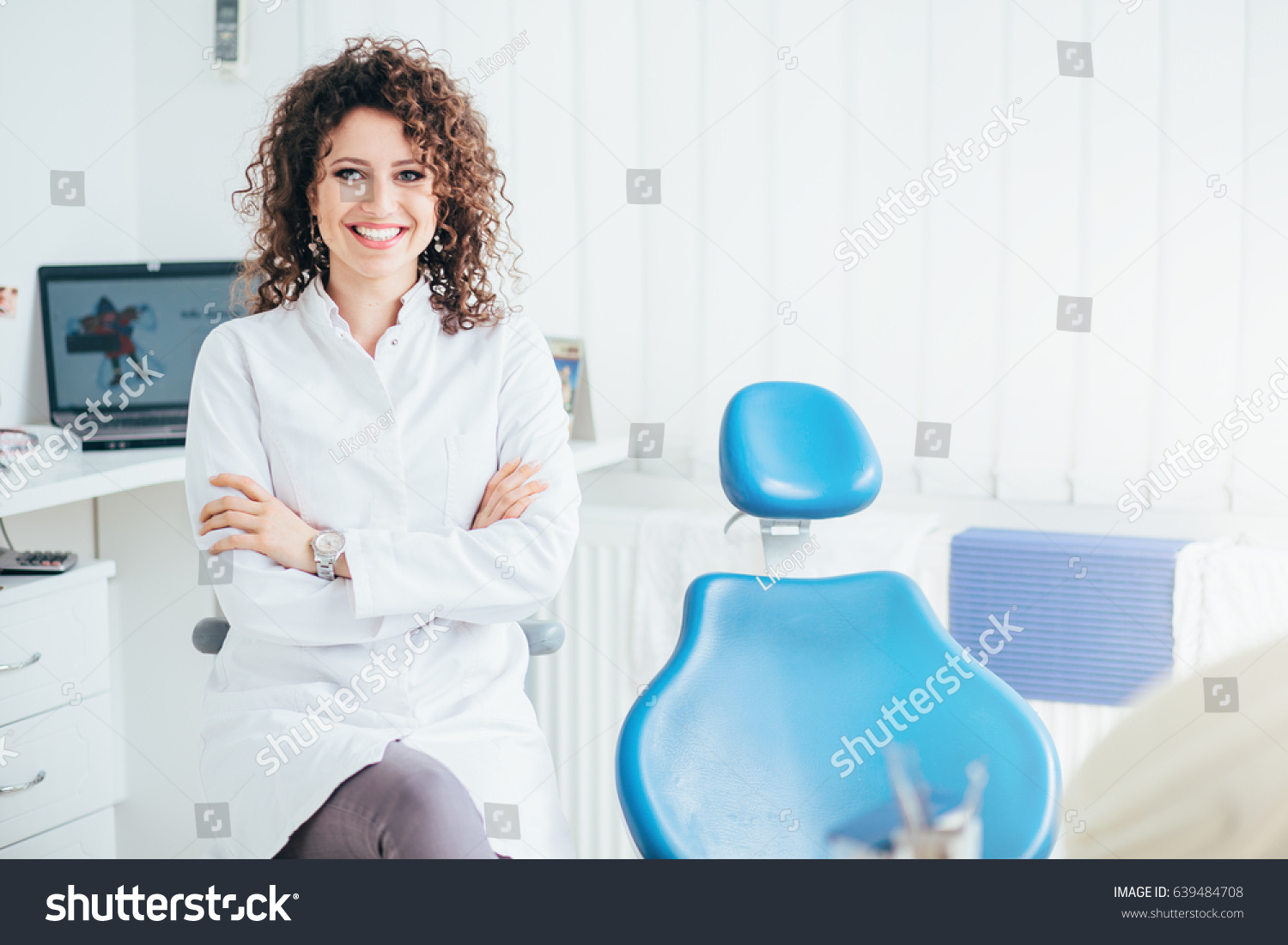 Portrait of female dentist. She standing at her office and she has beautiful smile. #639484708