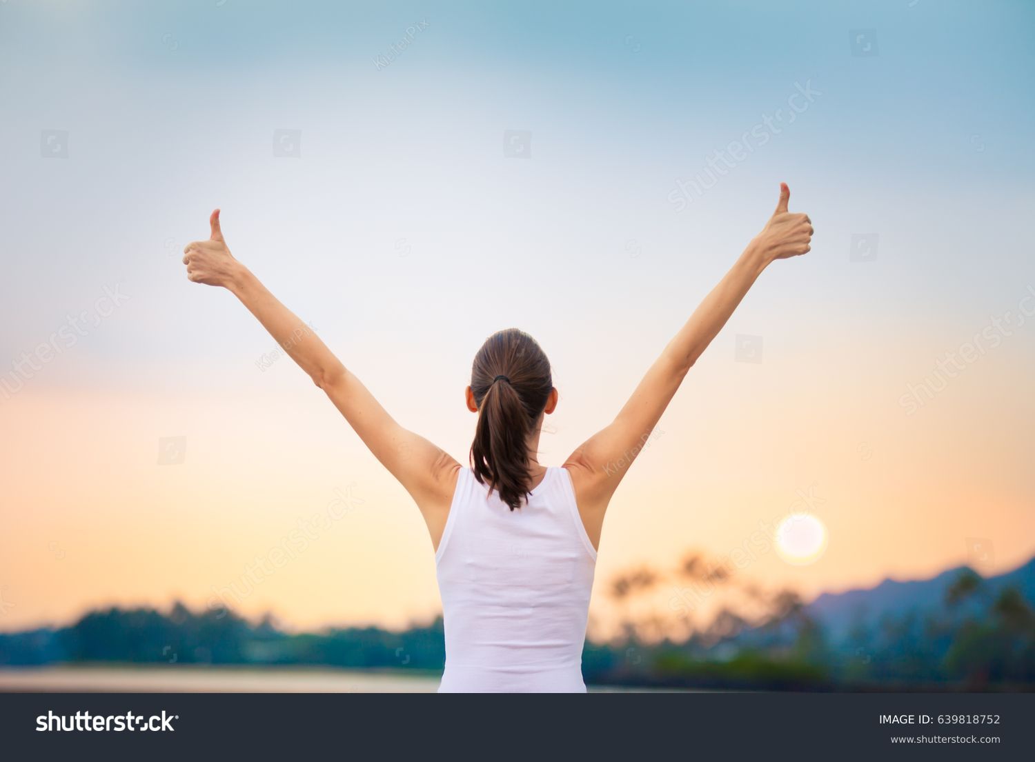 Winning, success and life goals concept. Young woman with arms in the air giving thumbs up. #639818752