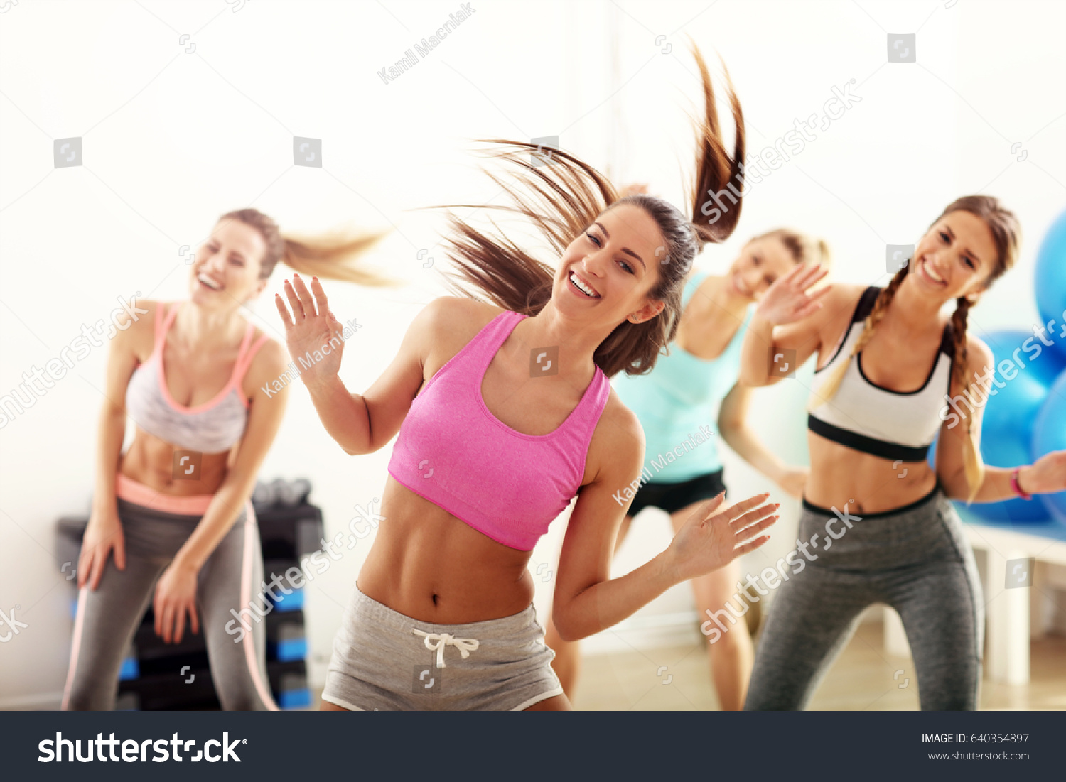 Group of happy people with coach dancing in gym #640354897