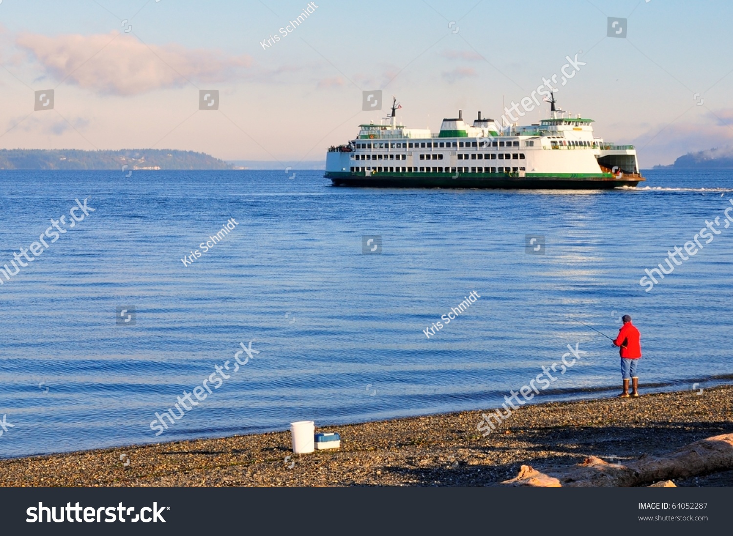 Automobile ferry crossing water with fisherman in the foreground #64052287