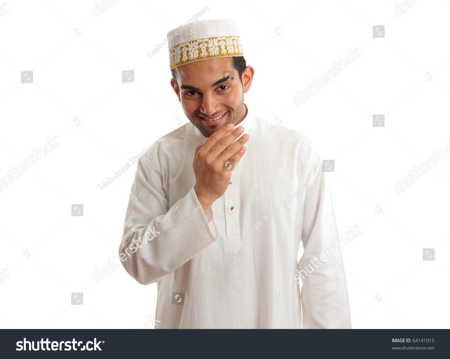 Smiling friendly ethnic man wearing a traditional embroidered robe with ruby buttons and a white and gold embroidered topi hat.  White background. #64141015